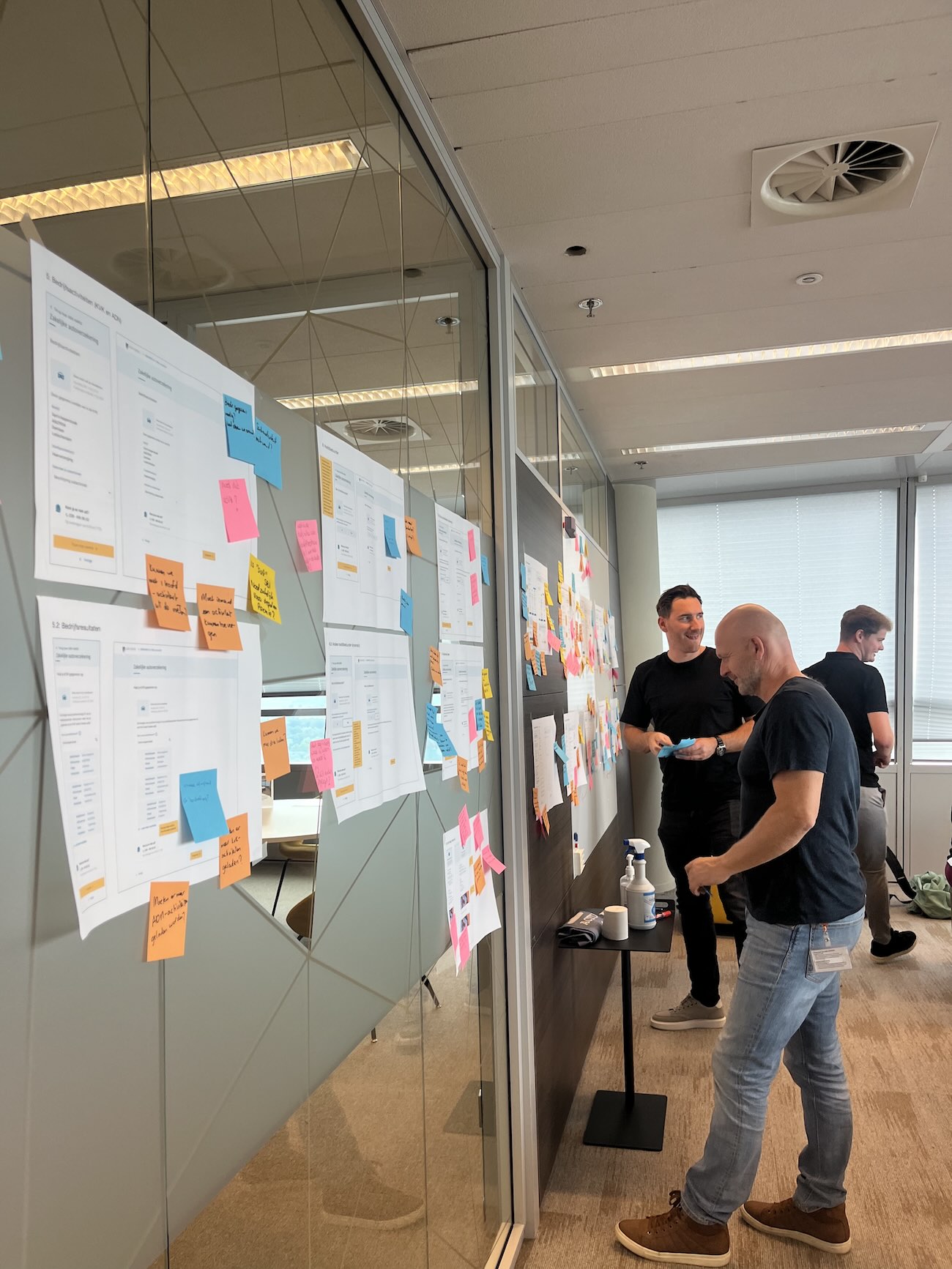 Stakeholder workshop reviewing usability test findings on printed screens and sticky notes